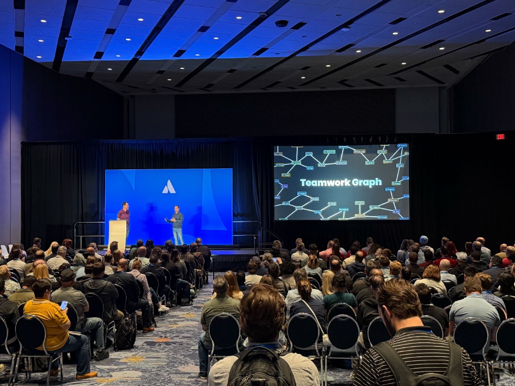 Dushyant Sharma on stage at Atlassian Team ’26 with the Teamwork Graph slide and a packed audience.